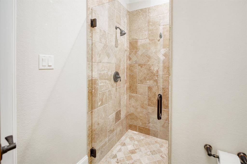 Walk-in shower with glass door.