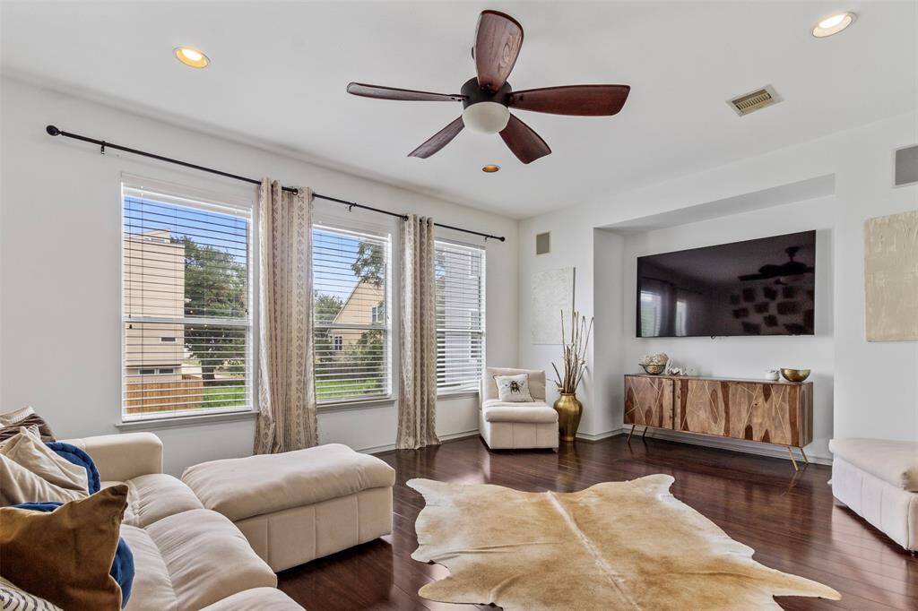 Bright and airy living room with large windows allowing natural light to flood the space. The open floor plan features contemporary design elements and hardwood floors,  Perfect for relaxing or entertaining guests