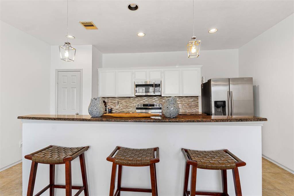 Step into a contemporary culinary haven where the kitchen effortlessly flows into the dining area, creating a harmonious space designed for both functionality and style. The kitchen features sleek, modern cabinetry with a sophisticated finish, complemented by a large island that serves as both a prep space and a casual eating spot.