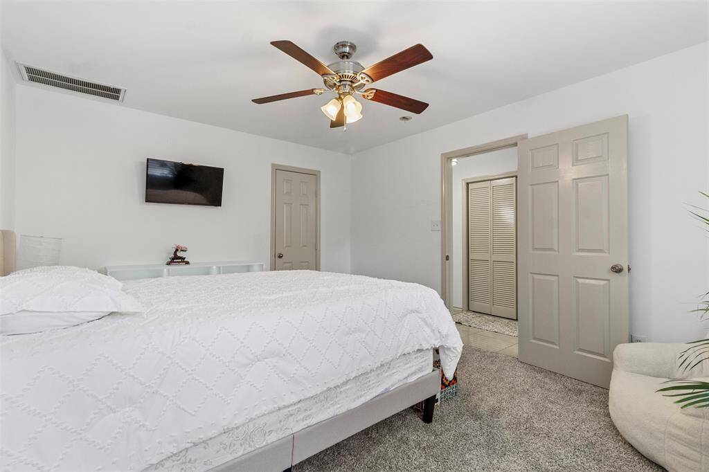 Bright and inviting guest bedroom with ample closet space and large windows. This room is perfect for visitors or could serve as a home office or study.