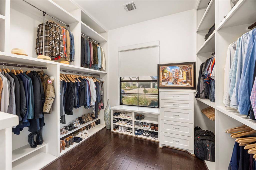 Large primary closet with site built drawers and shelves.