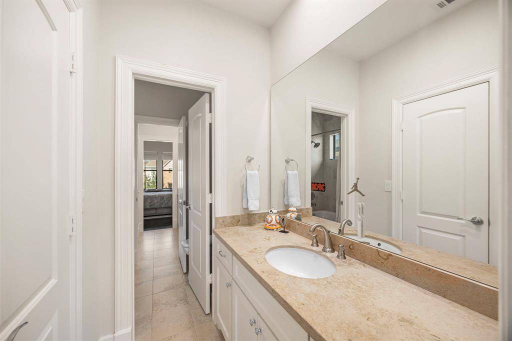 Vanity area from the adjacent bedroom. Shared shower and water closet.
