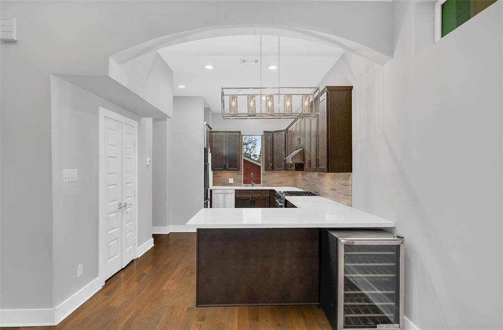 High ceilings, recessed lighting and a bright windows complete the space. There is the perfect counter seat right by the beverage fridge.