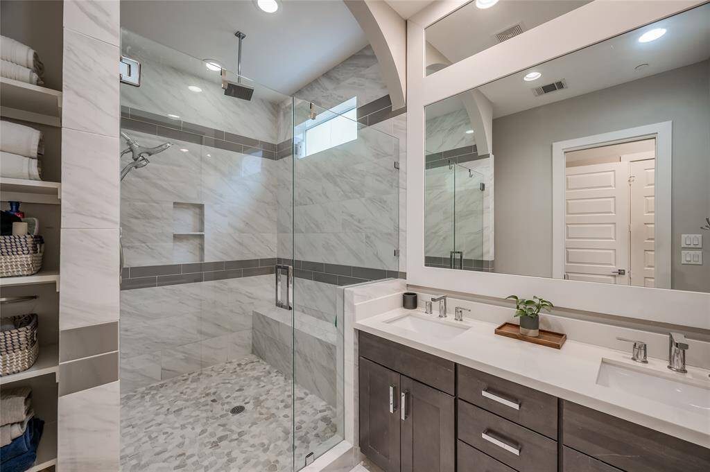 Beautiful storage options: open shelving for towels, drawers in the vanity, and a walk-in closet behind you.