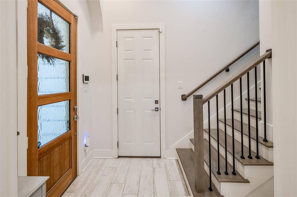 The ripple glass from the tall front door brings natural light to the entry hall. The other door leads to the 2 car garage. You'll love the storage otions there.