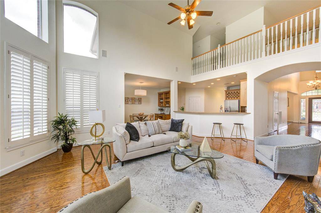 The soaring ceilings create a sense of grandeur, while the open floorplan seamlessly connects the living space to the kitchen and breakfast area.