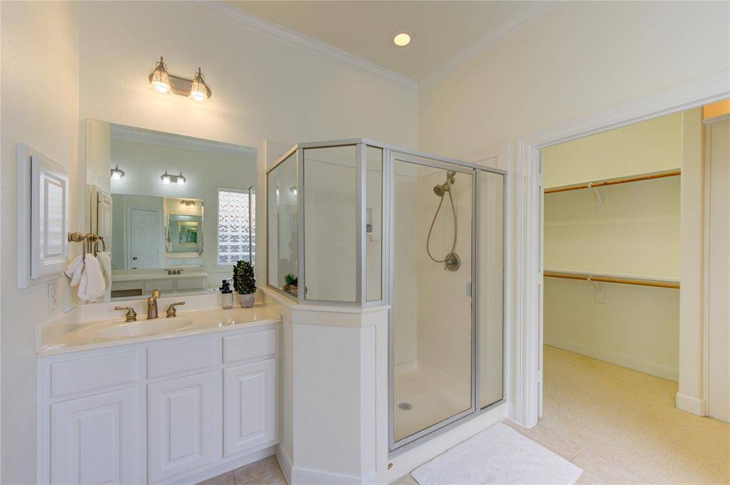 The spa-like primary bathroom offers both luxury and functionality, featuring a separate walk-in shower with updated fixtures and a soaking tub perfect for relaxation.