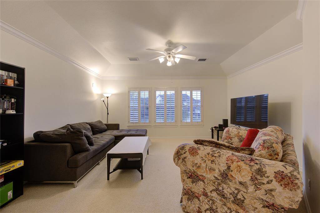 A spacious upstairs game room perfect for entertaining, complete with plush carpeting and large windows that bring in natural light.