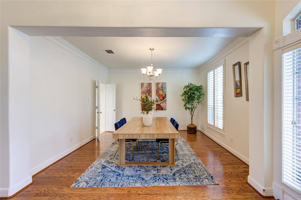 This elegant formal dining room is designed for both intimate dinners and grand gatherings. Featuring rich wood flooring, a stylish chandelier, and fresh paint throughout, the space exudes warmth and sophistication.