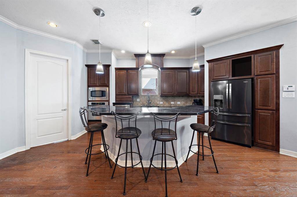 Prepare culinary masterpieces in the freshly painted gourmet kitchen, highlighted by stainless steel appliances, an oversized island with bar seating and multiple cabinetry.