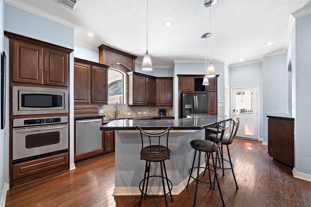 The spacious kitchen offers generous floor space, ideal for everyday use and entertaining. Find multiple custom cabinetry and a large islands thoughtfully designed for clutter-free storage.