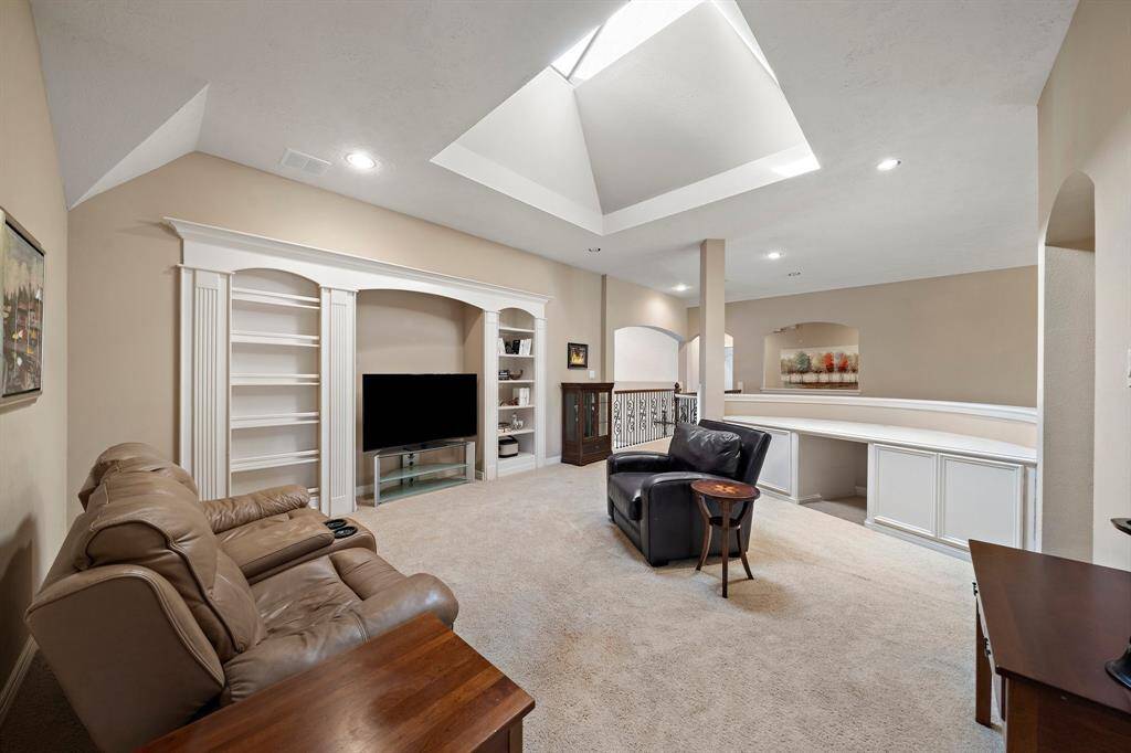 Located on the second floor, find an expansive game room featuring carpet flooring, multiple seating options for relaxation or entertainment, and custom built-ins.