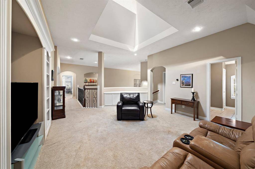 Brightened by a skylight, the second-floor game room offers custom built-ins and ample space for relaxation or entertainment. Its easy access to the main floor ensures added convenience for any occasion.