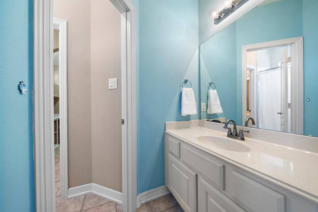 Featuring a vanity area with wide counter space and custom storage drawers, this secondary ensuite bath is the perfect combination of style and practicality for everyday convenience.