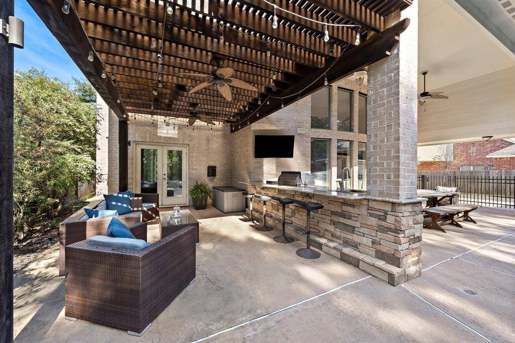 Just off the living area, the spacious patio serves as an idyllic outdoor entertainment area, featuring an outdoor kitchen and a granite bar with seating—all conveniently adjacent to the pool.