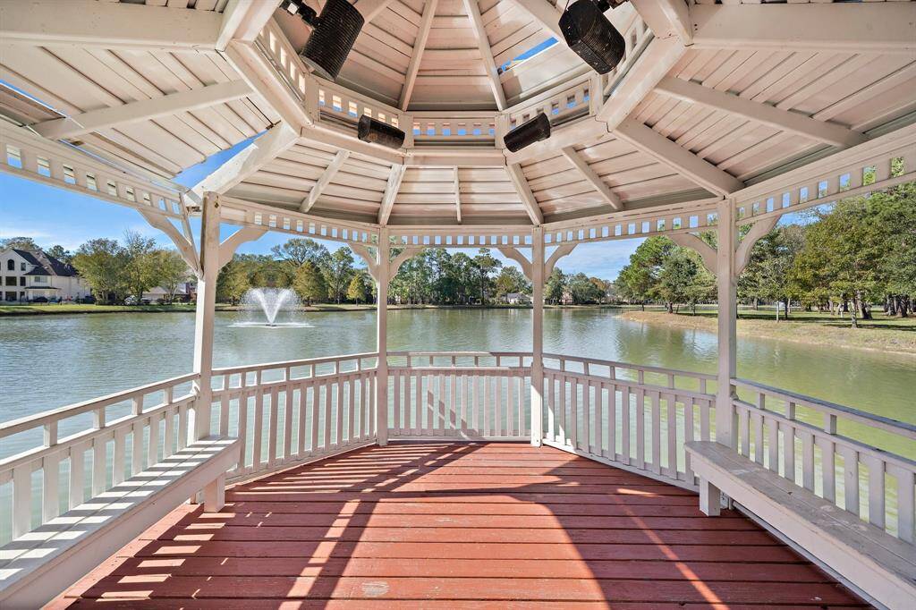 The Summerwood gazebo, set against the backdrop of a serene lake and fountain, invites you to enjoy the peaceful ambiance of the surrounding greenery.