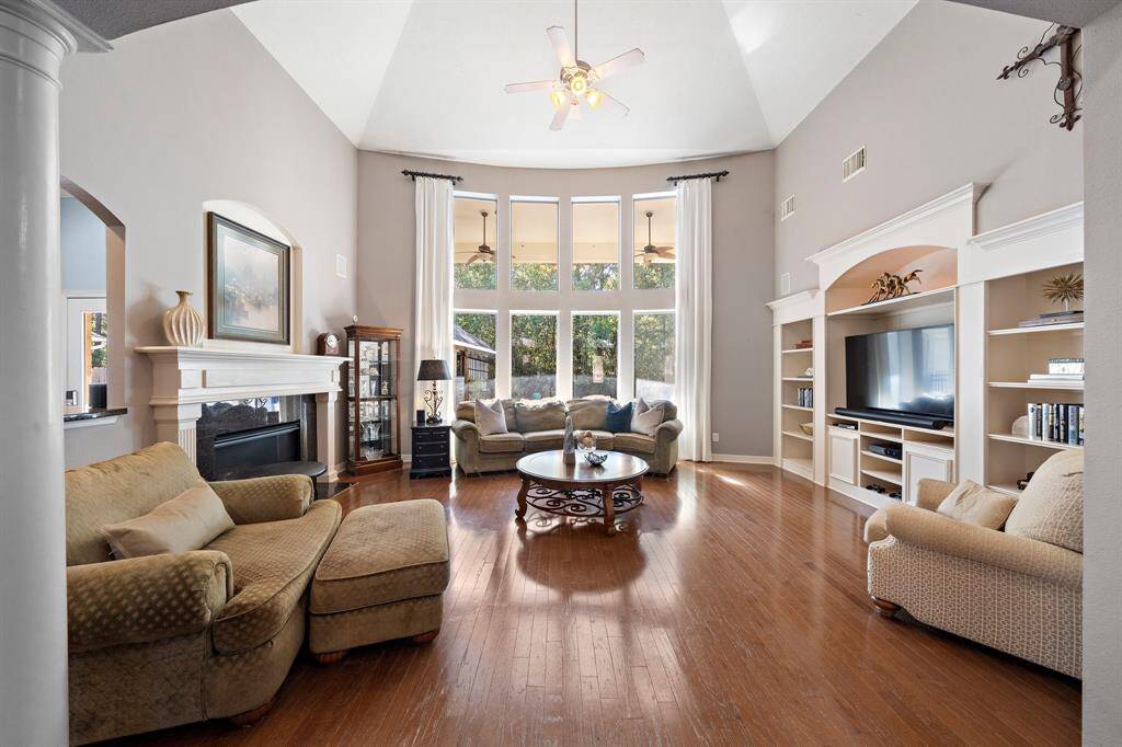 The light-filled living area boasts soaring ceilings, exquisite finishes, and a wall of windows that unveil breathtaking outdoor views. This elegant space provides the perfect backdrop for hosting unforgettable gatherings, blending luxury and natural beauty seamlessly.