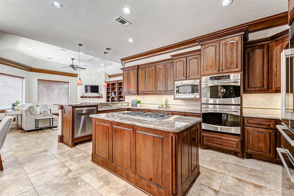 Open to the breakfast room and family room, this kitchen offers seamless flow for entertaining. A spacious breakfast bar with stylish pendant lighting provides additional seating, making it the perfect spot for casual meals or gathering with guests