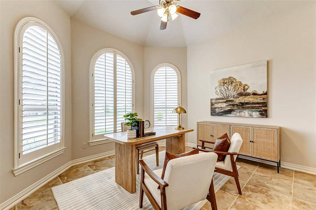 This versatile room features elegant plantation shutters, a stunning bay window, and soaring 12' ceilings. Designed as a private space with flexibility, it includes an ensuite bathroom with a walk-in shower, granite countertops, and a spacious walk-in closet. Ideal as a home office or second downstairs bedroom, it was previously used as a comfortable guest suite for elderly parents, easily accommodating a queen bed, nightstands, dresser, and chair.