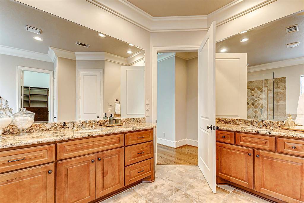 The Solarius granite countertops enhance the elegance of the Benedettini alder cabinets with a cocoa finish, The large vanity area offers generous counter space providing ample storage.