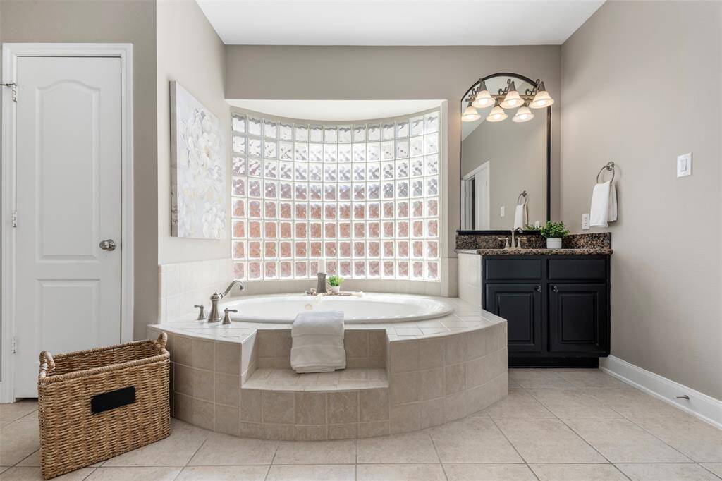 Ensuite primary bath has dual vanities, granite countertops, garden tub and an enormous closet.