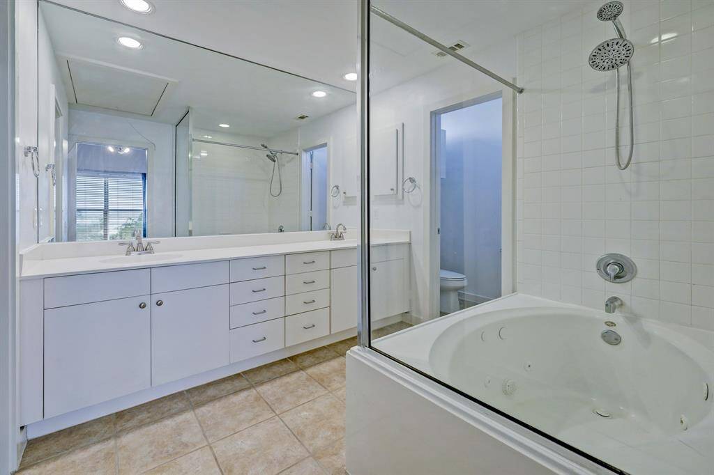 Primary bath features dual vanities and a soaking tub/shower combo.