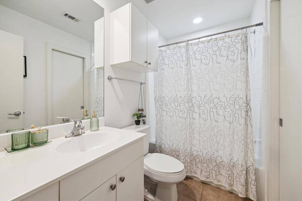 Secondary bedroom features stained concrete floors, an en suite bath, and a walk-in closet.