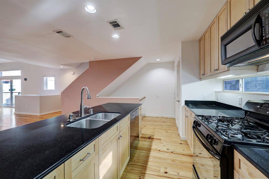 Kitchen features tons of cabinetry, black granite counter tops, and transom windows that allow in natural light.