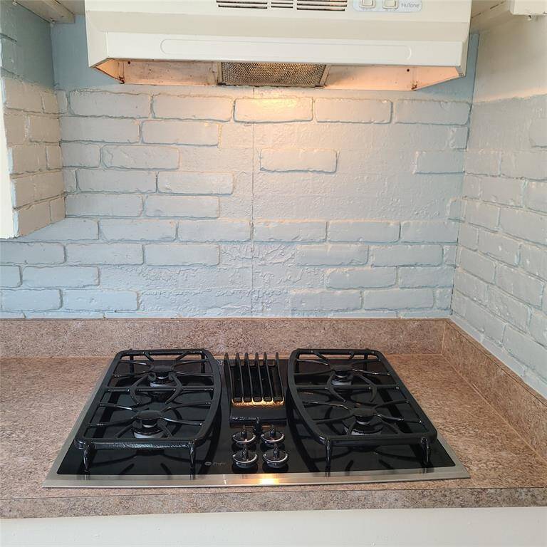 gas range with light blue vintage brick back splash.