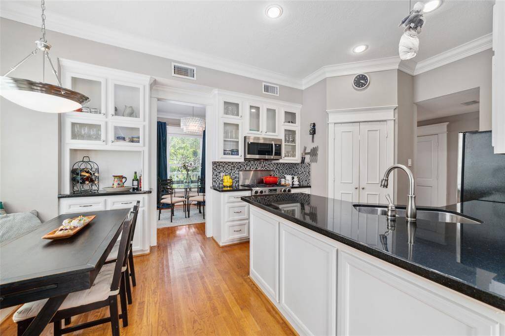Discover the well-equipped kitchen, featuring sleek granite countertops and a convenient wine/coffee nook. The eat-in area offers a cozy space for casual dining, making this kitchen both functional and inviting.