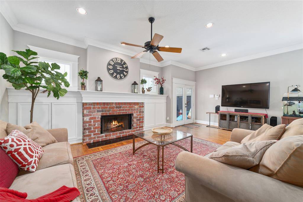 The living room features a cozy gas log fireplace with an impressive mantle, ample storage, and French doors that open to the backyard brand new deck.