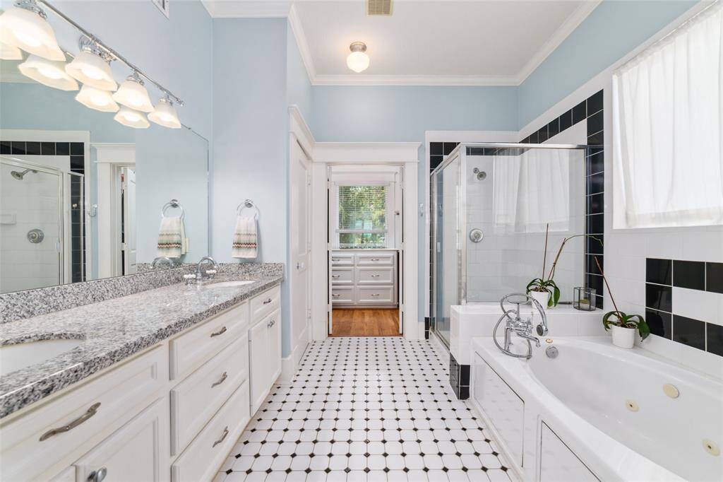 The primary ensuite boasts double sinks, a jetted tub, and a separate shower, private water closet, combining an old-world charm with modern conveniences.