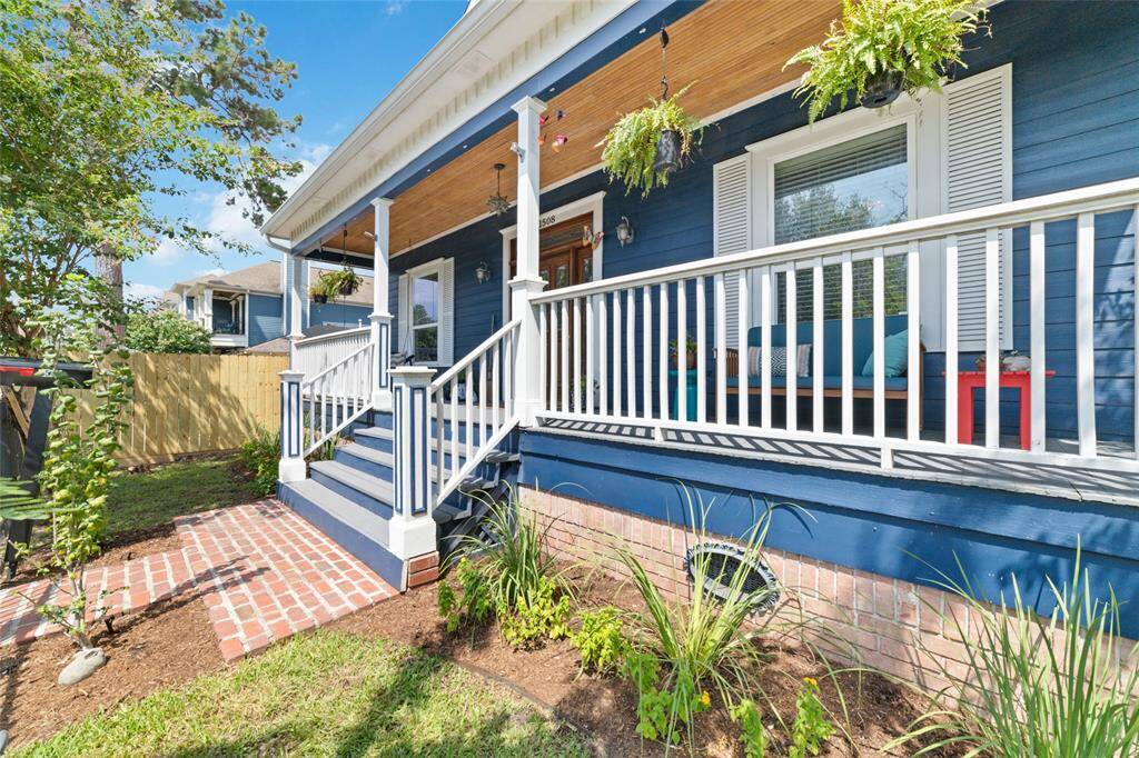 A spacious front porch with a beautifully crafted birchwood ceiling overlooks newly landscaped garden beds.