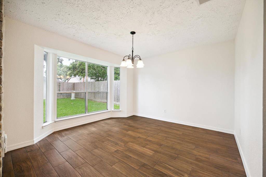 This elegant dining area is the perfect space to host everything from lavish dinner parties to casual family gatherings. Find wood-look tile flooring, fresh neutral paint, a stylish chandelier and oversized windows with picture-perfect views of the back yard.