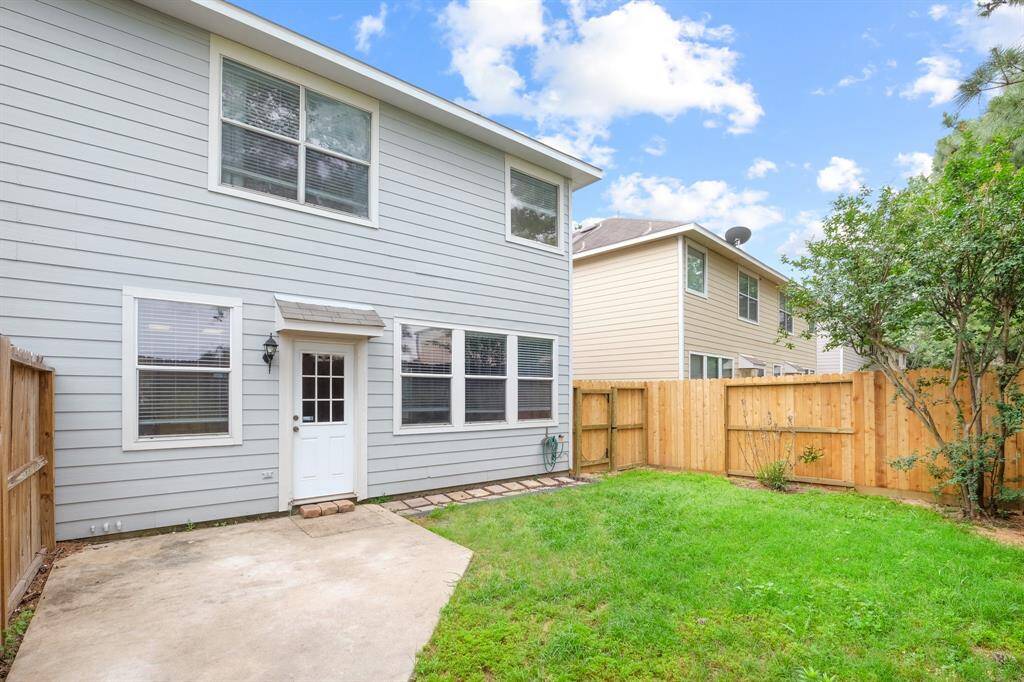 Spacious background with concrete patio for grilling and relaxing outside.