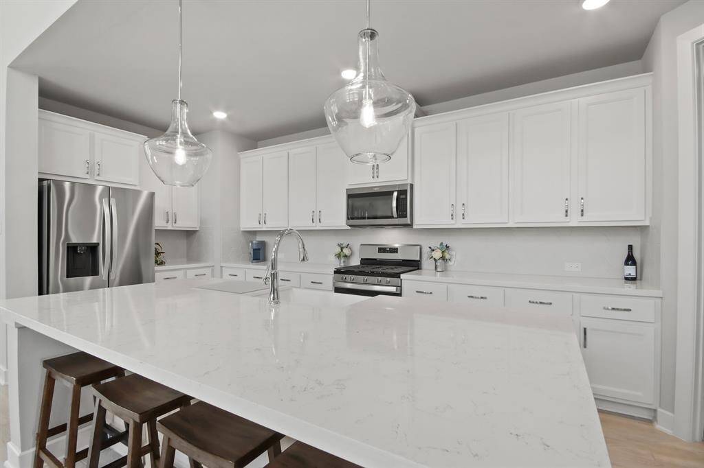 Beautiful hanging light fixtures and large island for additional seating.
