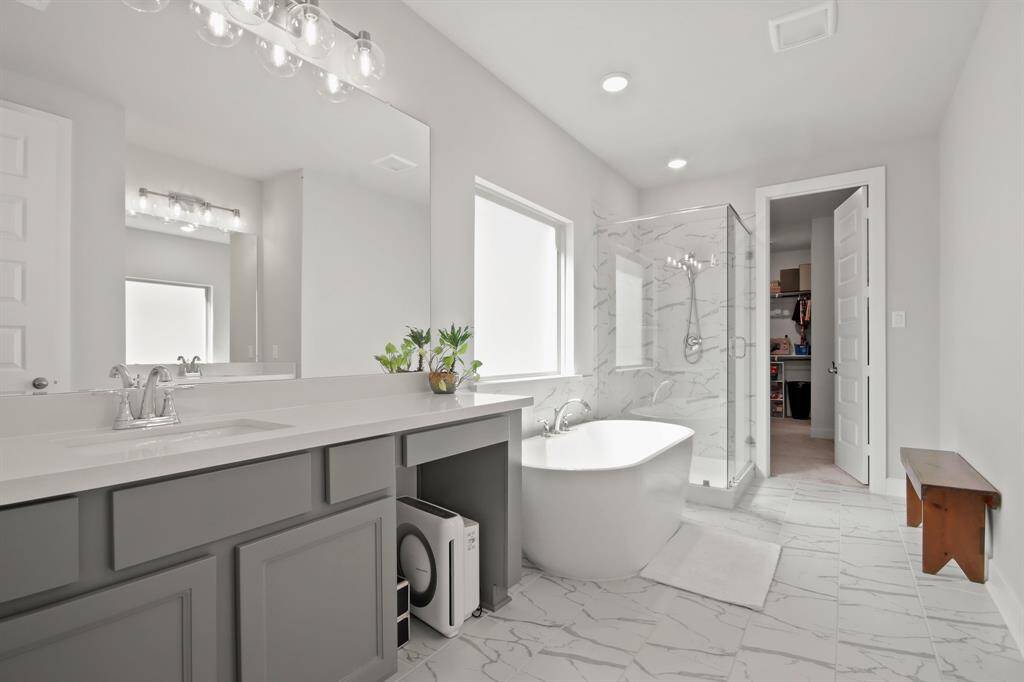 Primary bathroom has custom tile, soaking tub and separate shower.