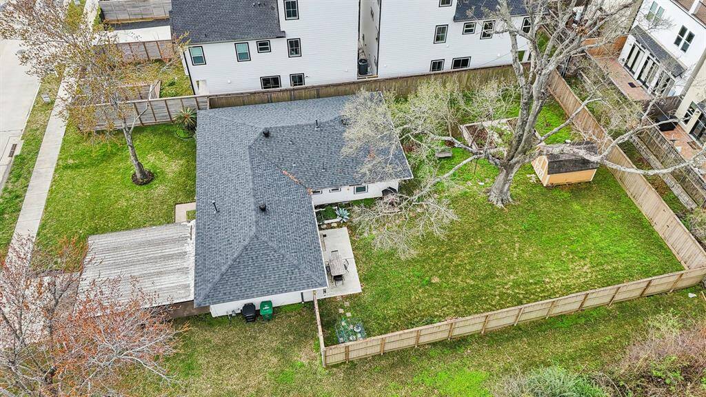 This aerial view showcases this home's oversized lot. The lot has mature trees, a shed, and ample outdoor space for activities and gardening.