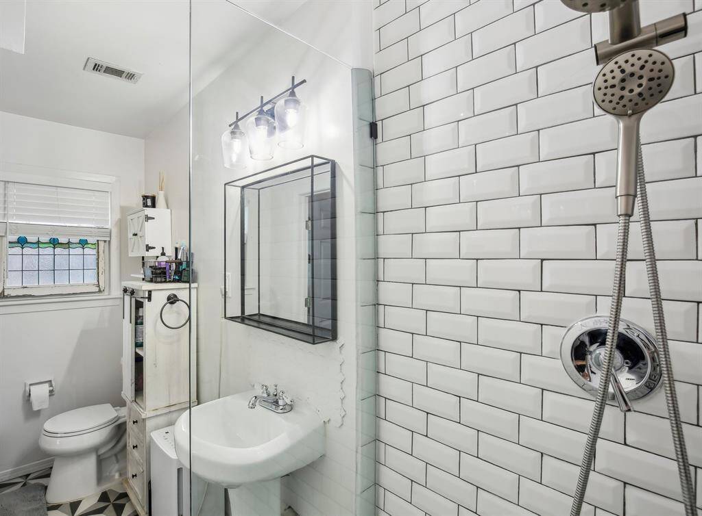 The master bathroom features a modern design with a glass-enclosed shower.