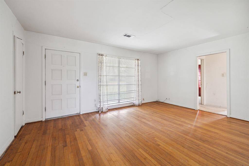 Living room with coat closet and large front windows.