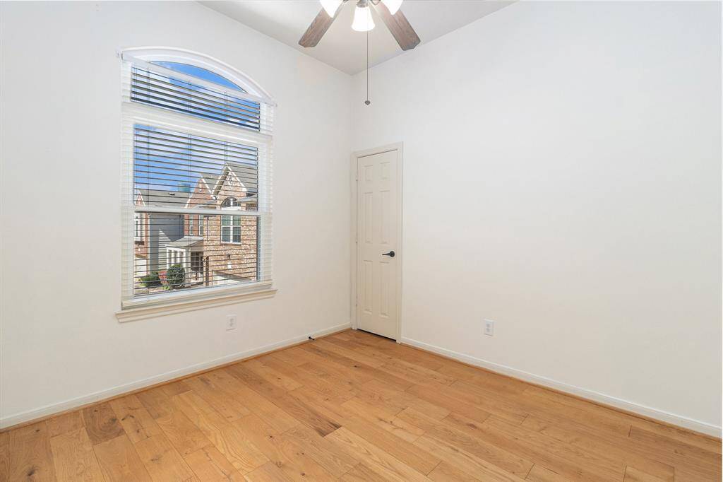 The primary bedroom boasts oversized windows, elegant drapes, and a trendy accent wall!