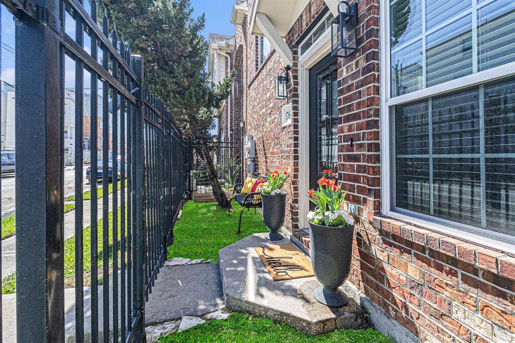 Timeless black door with matching planters and bench that convey with the home.