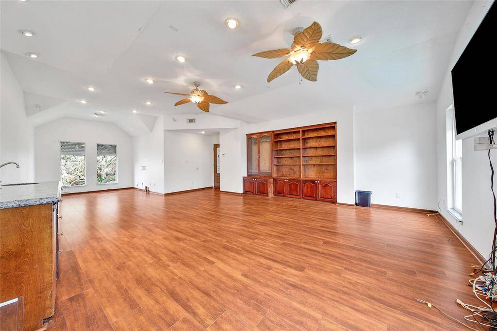 The bonus room upstairs features a gun closet with locks, built-in bookcase and wet bar with sink and mini fridge.