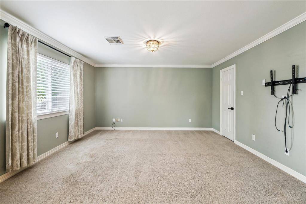 The upper level media room is an extension of the game room and features carpet floor, crown molding and storage closet.