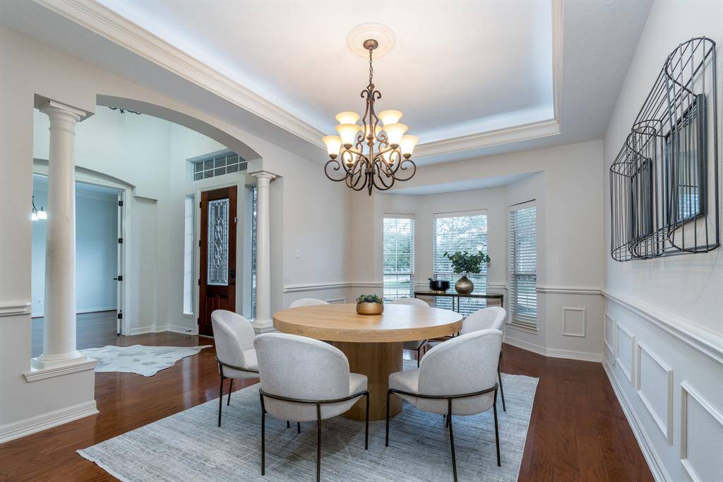 Upon entering, you are welcomed by a grand foyer and spiral staircase. Notice the wood flooring that seamlessly flows into the spacious main living areas.