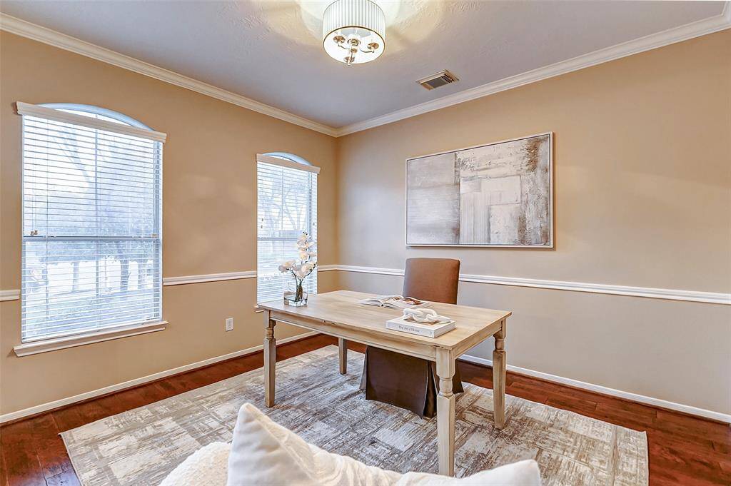 Whether used as a formal living room or a home office, this versatile space features a wall of windows, flooding the room with natural light.