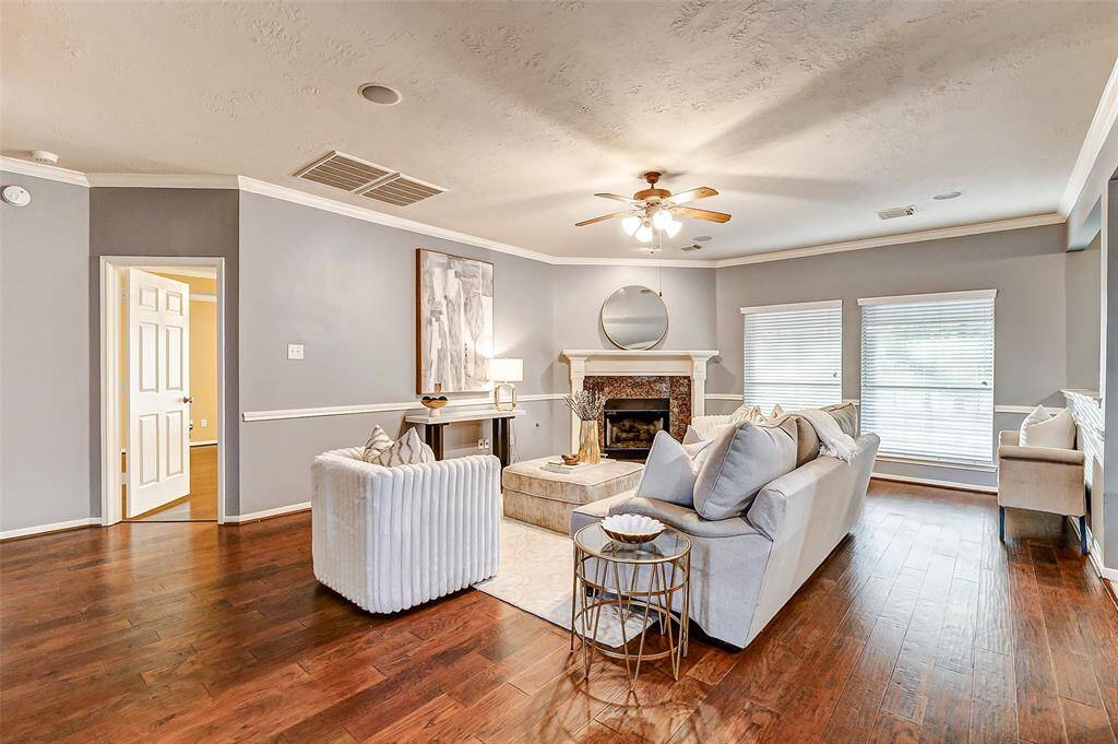 The family room features elegant crown molding, a corner gas log fireplace with a granite surround, and built-in speakers for an enhanced audio experience.