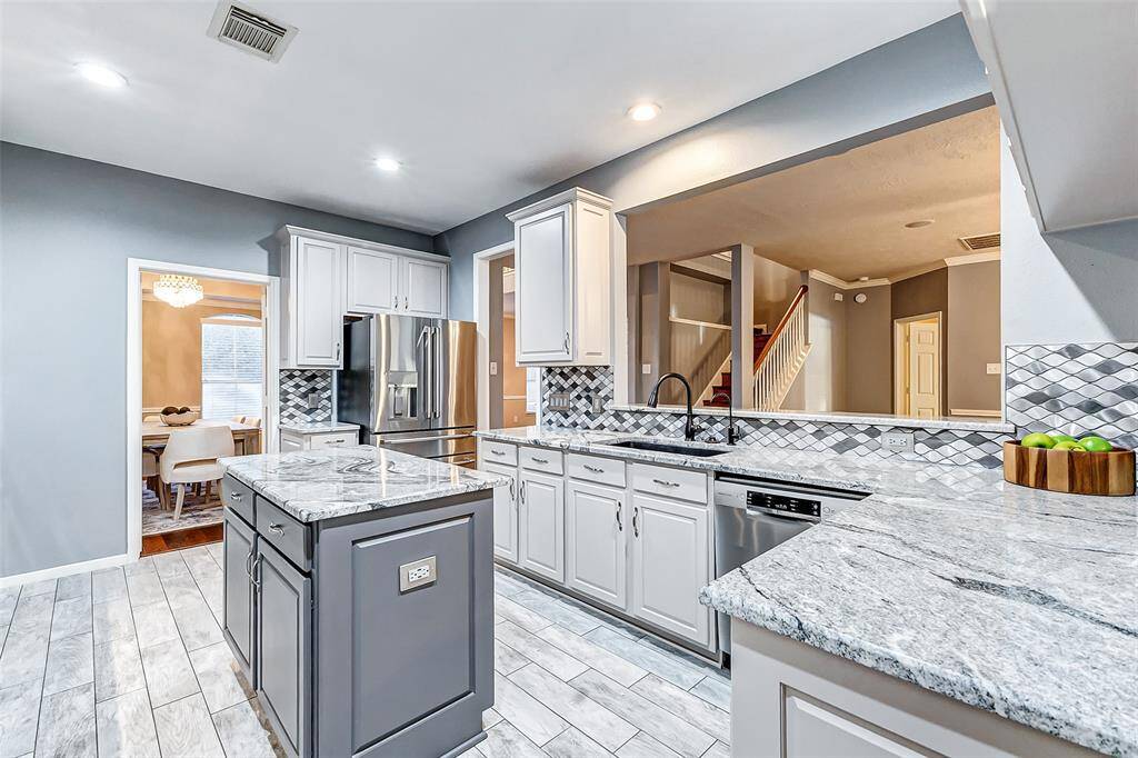 The kitchen is even more beautiful in person, showcasing gorgeous granite countertops, neutral gray cabinets, and a spacious undermount sink.