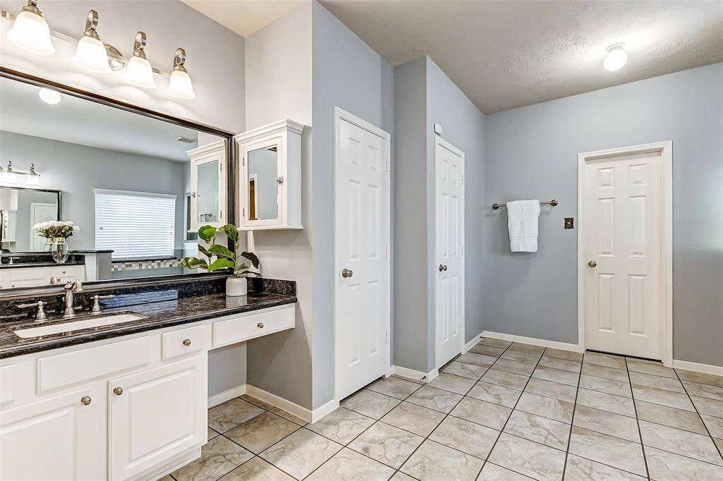 The primary bathroom is equipped with separate vanities, offering ample space and a functional layout for added comfort and convenience.