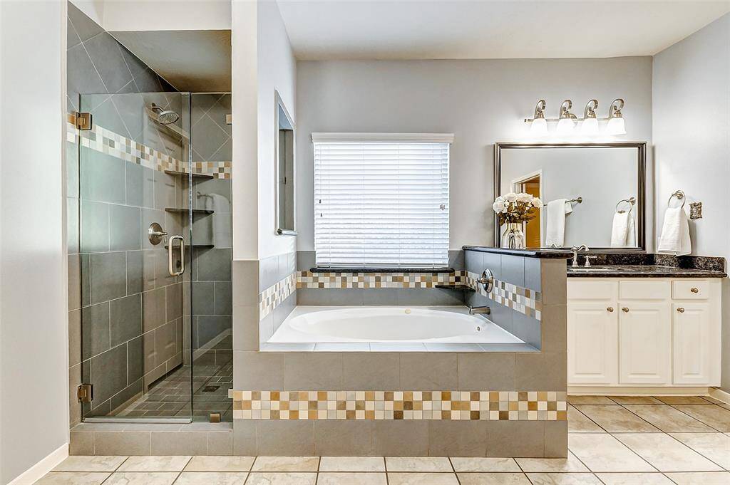 The primary bathroom includes a separate shower and a luxurious jetted tub, providing the perfect space to relax and unwind.